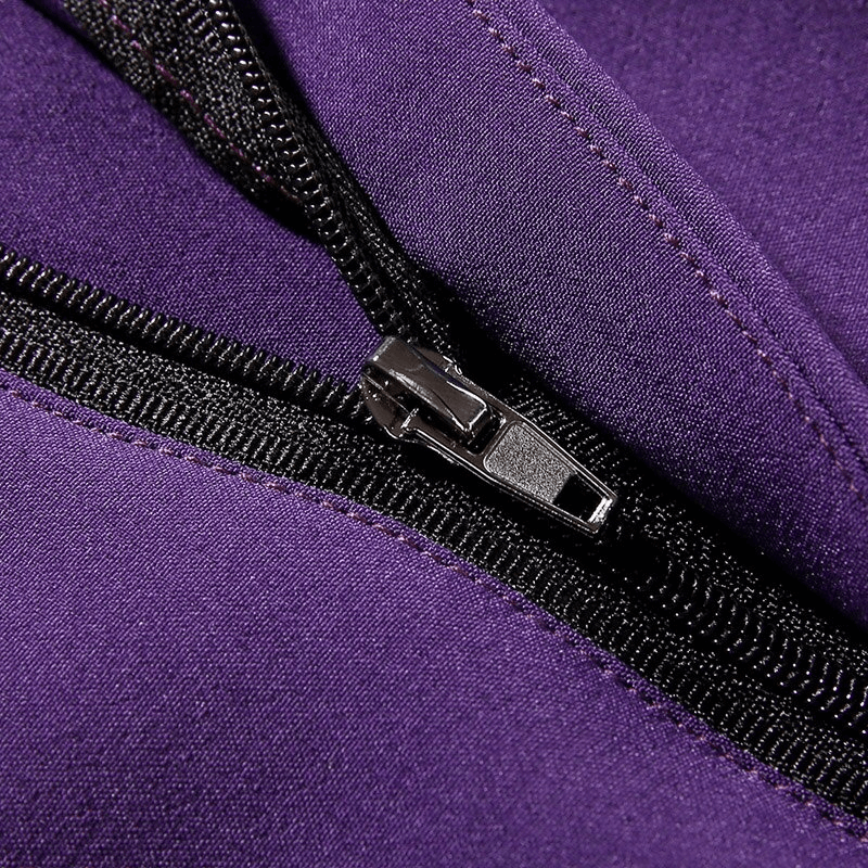 Close-up of zipper fly on purple waterproof fleece women's hiking pants, showcasing durable fabric and construction.